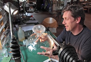 Ein Mann graviert eine Glasvase. Ein Mann graviert eine Glasvase.