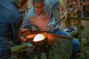 Schauproduktion im Glasturm: ein Mitarbeiter mit einer rot glühenden Kugel an der Glasmacherpfeife. Schauproduktion im Glasturm: ein Mitarbeiter mit einer rot glühenden Kugel an der Glasmacherpfeife.